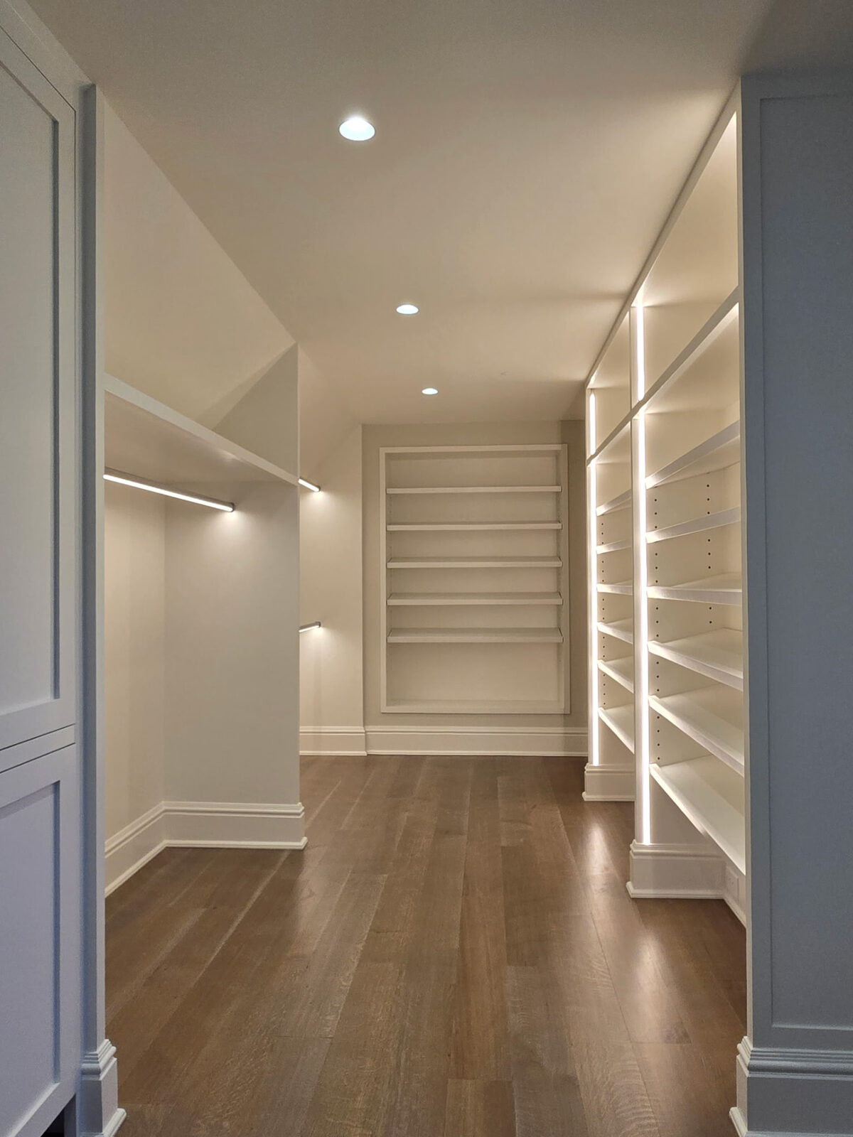 Custom walk-in closet with illuminated shelving and built-in drawers in a Ridgefield, CT home